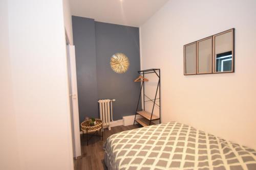 a bedroom with a bed and a mirror on the wall at CONFORT APPART - HYPERCENTRE - TRAMWAY - leRelaisdOdile14 in Valenciennes