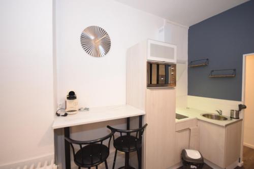 a small kitchen with a counter and two stools at CONFORT APPART - HYPERCENTRE - TRAMWAY - leRelaisdOdile14 in Valenciennes