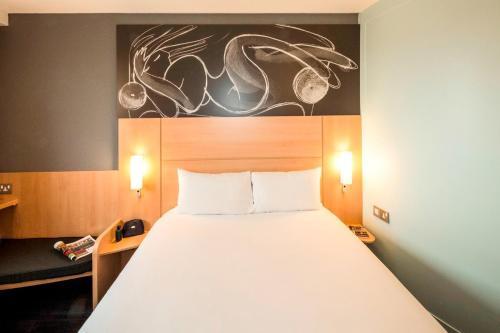 a bedroom with a large white bed in a room at ibis Bordeaux Lac in Bordeaux