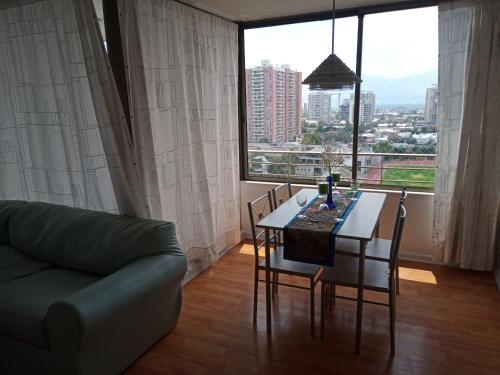 un soggiorno con tavolo, sedie e divano di Departamento Impecable a Santiago
