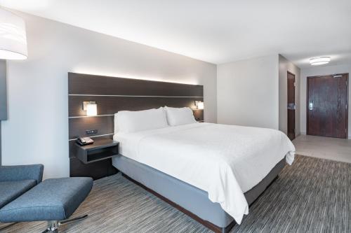 a hotel room with a large bed and a chair at Holiday Inn Express & Suites Trinidad by IHG in Trinidad