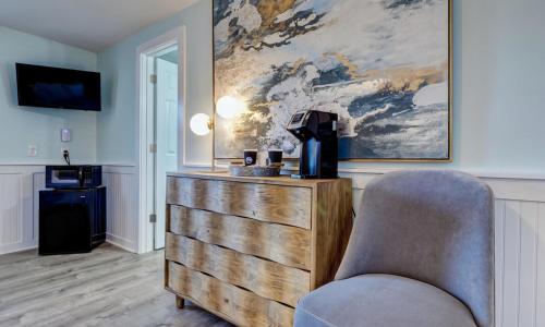 a living room with a dresser and a chair at Loggerhead Inn and Suites in Surf City