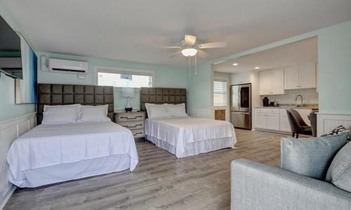 a bedroom with two beds and a couch at Loggerhead Inn and Suites in Surf City