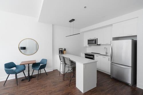 a kitchen with a refrigerator and a table and chairs at Sonder Gare Saint Denis in Montréal
