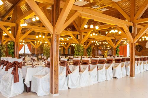 een feestzaal met witte tafels en stoelen bij Complex Turistic Darina Sancraiu de Mures in Sîncraiu de Mureş