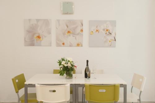 a dining room table with chairs and a bottle of wine at Karboni Hotel in Mýkonos City