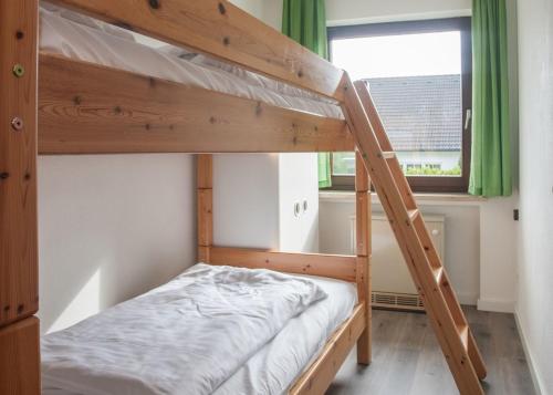 een stapelbed in een kleine kamer met een ladder bij Ferienwohnung - Am Roten Kreuz 11 in Winterberg