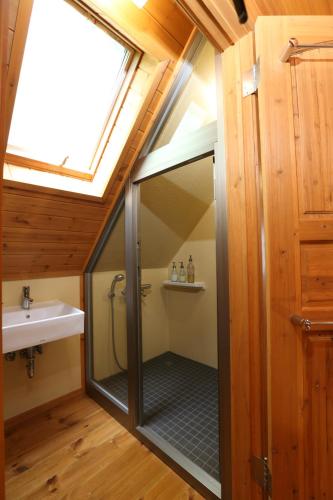 a bathroom with a shower and a sink at Big Bear Chalets & Apartments in Hakuba