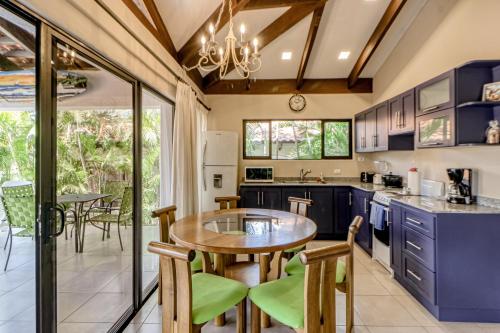 a kitchen with blue cabinets and a table and chairs at Villa Sol in Playa Hermosa