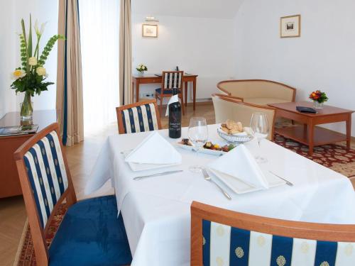 a dining room with a white table and chairs at Hotel Ambassador in Vienna
