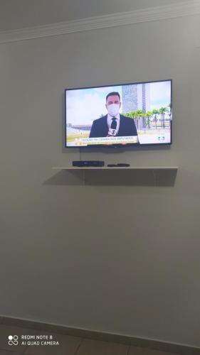 un écran de télévision avec un homme portant un masque dans l'établissement Pousada Quarto Suíte Famíliar com ar,frigobar, wi fi e garagem, à Aparecida