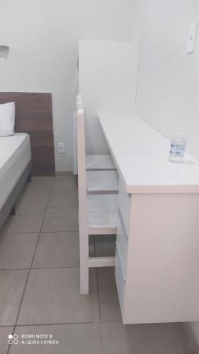- une chambre avec un bureau et un lit dans l'établissement Pousada Quarto Suíte Famíliar com ar,frigobar, wi fi e garagem, à Aparecida
