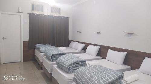 Habitación con 4 camas y almohadas. en Pousada Quarto Suíte Famíliar com ar,frigobar, wi fi e garagem, en Aparecida