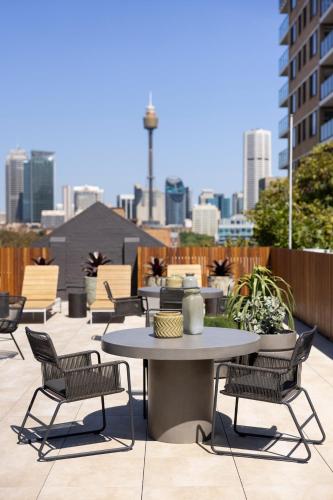 a table and chairs on a patio with a city skyline at Regents Court Sydney in Sydney