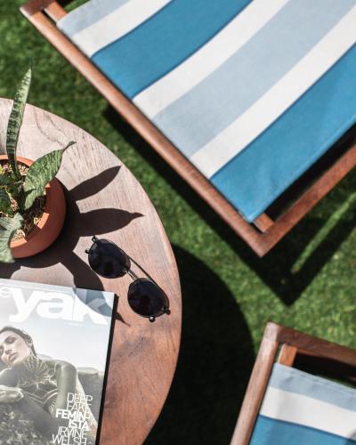 a table with a book and a plant on the grass at MAMAKA by Ovolo in Kuta