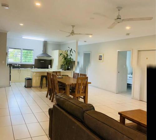 ein Wohnzimmer mit einem Sofa und einem Tisch sowie eine Küche in der Unterkunft Martyn st house in Cairns
