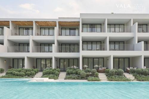 an exterior view of a building with a swimming pool at VALA Hua Hin - Nu Chapter Hotels in Cha Am