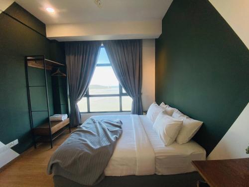 a bedroom with a large bed with a green wall at Kuantan Imperium by Glex in Kuantan