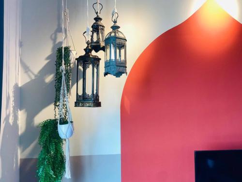 two chandeliers hanging in a room with a red wall at Kuantan Imperium by Glex in Kuantan