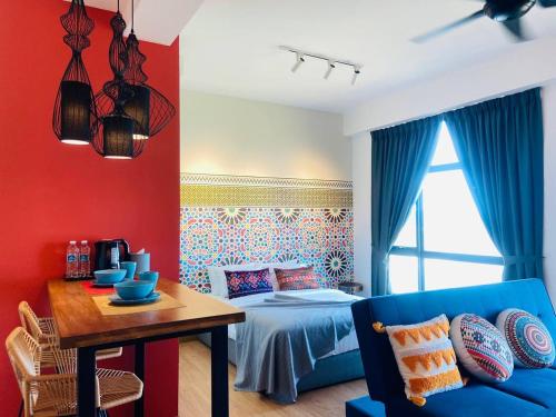 a room with a bed and a table with a blue couch at Kuantan Imperium by Glex in Kuantan