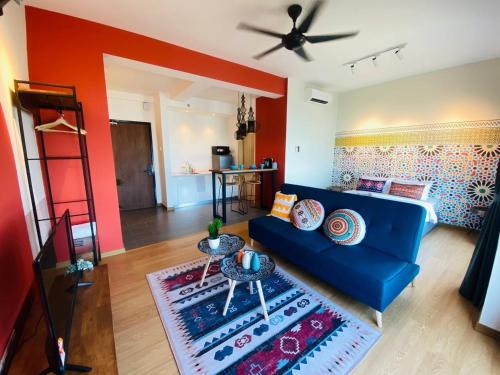 a living room with a blue couch and red walls at Kuantan Imperium by Glex in Kuantan
