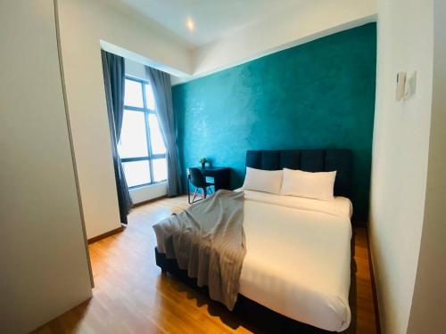 a bedroom with a bed and a blue wall at Kuantan Imperium by Glex in Kuantan