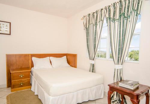 a bedroom with a bed and a window at Caribbean Inn and Suites in Saint Johnʼs