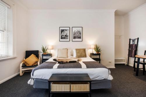 a bedroom with a large bed and a table at The Woolpack Hotel in Mudgee