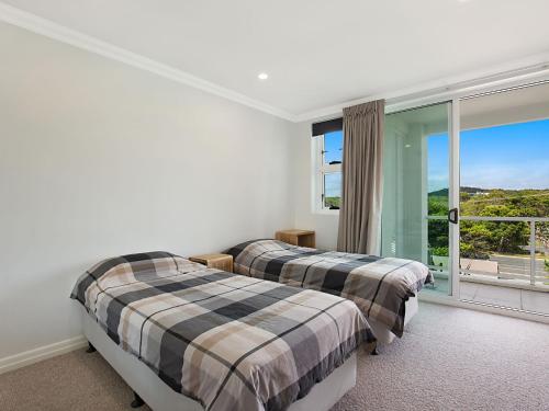 twee bedden in een kamer met een groot raam bij Solaya Unit 6 in Gold Coast