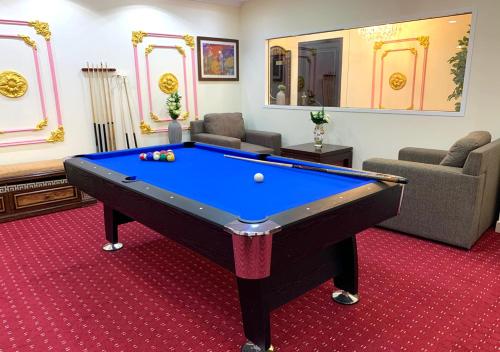 a room with a pool table in a living room at Majestic Hotel in Doha