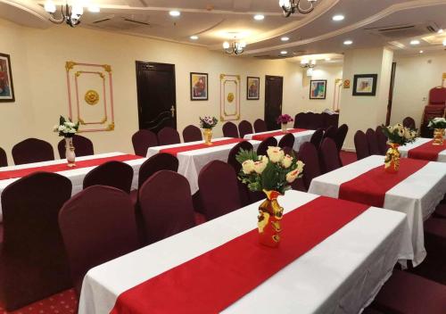 a conference room with red and white tables and chairs at Majestic Hotel in Doha