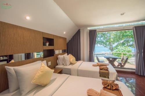 ein Hotelzimmer mit 2 Betten und einem Balkon in der Unterkunft Chai Chet Resort Koh Chang in Ko Chang