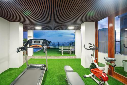 a fitness room with a treadmill and a scooter at Apus Hotel in Nha Trang