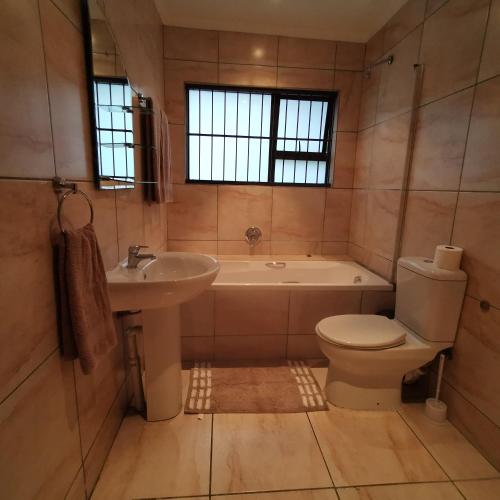 a bathroom with a tub and a toilet and a sink at The Hide on Devereux in East London