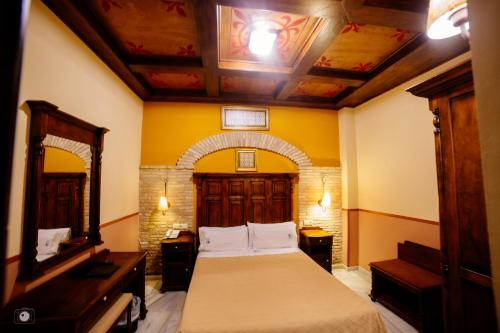 a bedroom with a bed and a mirror in a room at Hotel Posada de Vallina by MiRa in Córdoba