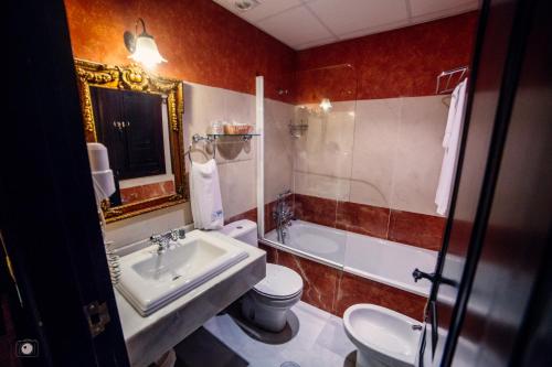 a bathroom with a sink and a toilet and a tub at Hotel Posada de Vallina by MiRa in Córdoba