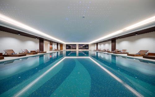 una gran piscina con sillas en un edificio en Optical Valley Convention Hotel en Wuhan