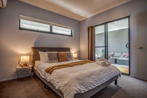 a bedroom with a bed and a large window at Maylands Boutique Apartments in Perth