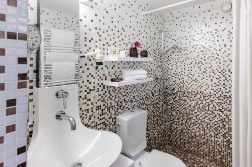 a small bathroom with a toilet and a sink at Mercure Hotel Berlin Zentrum Superior in Berlin