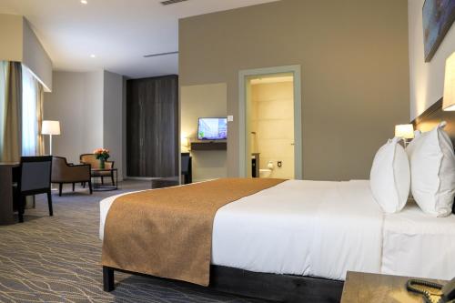 エルドレットにあるEka Hotel Eldoretの大きなベッドとリビングルームが備わるホテルルームです。