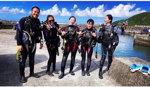 a group of people standing next to the water at 綠島玉米-潛水住宿 Diveholix Homestay in Green Island