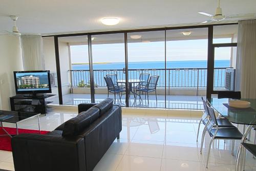 a living room with a couch and a table with chairs at Cairns Aquarius in Cairns