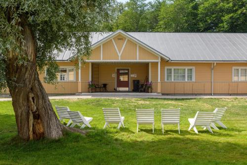 a group of white chairs in front of a house at FolkiaCenter Gästhem - Vieraskoti - Guesthouse in Hanko