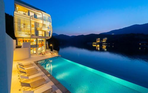 a house with a swimming pool next to a body of water at Gapyeong Suiteian Hotel&Resort in Gapyeong