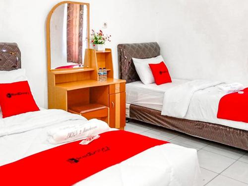 a hotel room with two beds and a mirror at RedDoorz near Reremi Pemancar Manokwari in Manokwari
