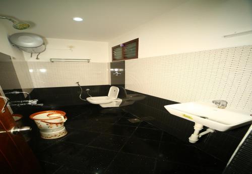 a bathroom with a toilet and a sink at Arudhra Residency in Chidambaram