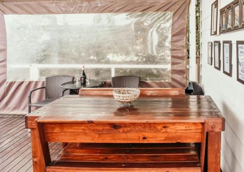 a wooden table and chairs on a porch with a window at Knock Out View Clarens in Clarens