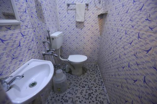 a bathroom with a white toilet and a sink at Le Apex Home Stay in Auroville