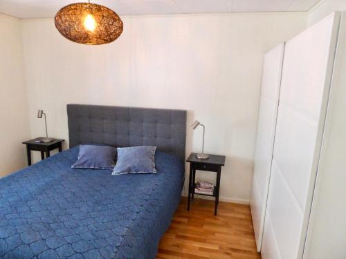 een slaapkamer met een blauw bed en 2 nachtkastjes bij Fjällbacka Centralt in Fjällbacka