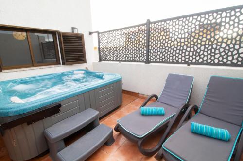 a bathroom with two chairs and a tub at MEDANO4YOU Casa Violeta in El Médano